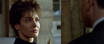 Movie still from “Nikita” (1990), directed by Luc Besson – A woman's face in a building; Close Up shot, Over the shoulder angle