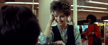 Movie still from “Nikita” (1990), directed by Luc Besson – A woman talking on a phone in front of a mirror; Close Up shot, Over the shoulder angle