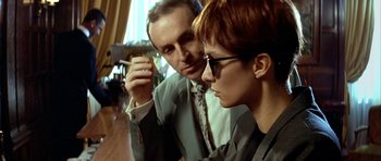 Movie still from “Nikita” (1990), directed by Luc Besson – A man and a woman looking at something on a table; Close Up shot, Low angle