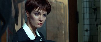 Movie still from “Nikita” (1990), directed by Luc Besson – A person with short brown hair; Close Up shot, Over the shoulder angle