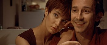 Movie still from “Nikita” (1990), directed by Luc Besson – A person sitting next to another person; Close Up shot, Over the shoulder angle