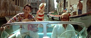 Movie still from “Nikita” (1990), directed by Luc Besson – A group of people riding on a boat in the water; Medium shot, Over the shoulder angle