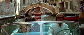 Movie still from “Nikita” (1990), directed by Luc Besson – A woman wearing a straw hat while standing on a boat; Wide shot, Over the shoulder angle