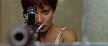 Movie still from “Nikita” (1990), directed by Luc Besson – A person looking through a microscope; Close Up shot, Low angle