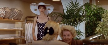 Movie still from “Nikita” (1990), directed by Luc Besson – A woman in a polka dot dress and a woman in a white hat; Medium shot, Over the shoulder angle