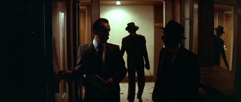 Movie still from “Nikita” (1990), directed by Luc Besson – A group of men standing in a hallway; Wide shot, Low angle
