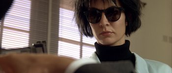 Movie still from “Nikita” (1990), directed by Luc Besson – A person wearing sunglasses; Close Up shot, Low angle