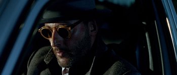 Movie still from “Nikita” (1990), directed by Luc Besson – A person wearing sunglasses and a hat; Close Up shot, Low angle