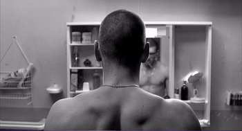 Movie still from “La haine” (1995), directed by Mathieu Kassovitz – A man with his back turned looking in the mirror; Close Up shot, Over the shoulder angle