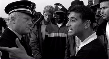 Movie still from “La haine” (1995), directed by Mathieu Kassovitz – A black and white photo of a group of people; Medium shot, Over the shoulder angle
