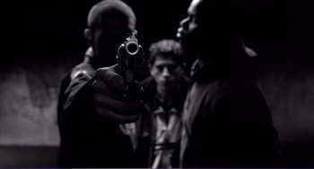 Movie still from “La haine” (1995), directed by Mathieu Kassovitz – A group of men standing next to each other holding guns; Medium shot, Low angle
