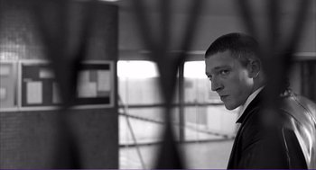 Movie still from “La haine” (1995), directed by Mathieu Kassovitz – A black and white photo of a man in a suit; Close Up shot, Low angle