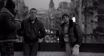 Movie still from “La haine” (1995), directed by Mathieu Kassovitz – Two young men standing next to each other on a city street; Medium shot, Low angle