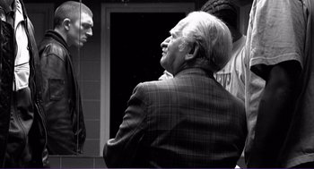 Movie still from “La haine” (1995), directed by Mathieu Kassovitz – A black - and - white photo of a man talking to another man; Medium shot, Over the shoulder angle