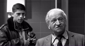 Movie still from “La haine” (1995), directed by Mathieu Kassovitz – An older man and a young boy in a bathroom; Medium shot, Over the shoulder angle