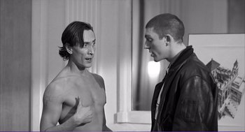 Movie still from “La haine” (1995), directed by Mathieu Kassovitz – Two men are standing next to each other; Medium shot, Over the shoulder angle