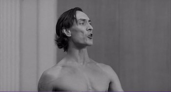 Movie still from “La haine” (1995), directed by Mathieu Kassovitz – A shirtless man with long hair is looking up; Close Up shot, Low angle