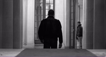 Movie still from “La haine” (1995), directed by Mathieu Kassovitz – A black and white photo of a man in a black jacket; Medium shot, Low angle