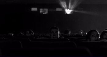Movie still from “La haine” (1995), directed by Mathieu Kassovitz – A group of people sitting in a movie theater; Wide shot, Low angle