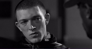 Movie still from “La haine” (1995), directed by Mathieu Kassovitz – A person wearing a leather jacket; Close Up shot, Low angle