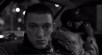 Movie still from “La haine” (1995), directed by Mathieu Kassovitz – A person in a black and white photo; Close Up shot, High angle