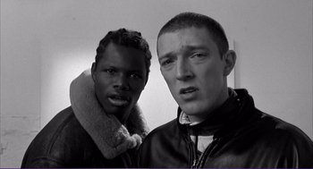 Movie still from “La haine” (1995), directed by Mathieu Kassovitz – Two young men posing for a picture in black and white; Close Up shot, Low angle