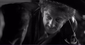 Movie still from “La haine” (1995), directed by Mathieu Kassovitz – A black - and - white photo of a man with a hat on; Close Up shot, Over the shoulder angle