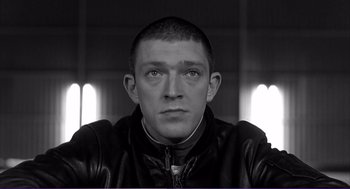 Movie still from “La haine” (1995), directed by Mathieu Kassovitz – Black and white photograph of a man in a leather jacket; Close Up shot, Low angle