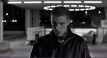 Movie still from “La haine” (1995), directed by Mathieu Kassovitz – Black and white photograph of a man in a leather jacket; Close Up shot, Low angle