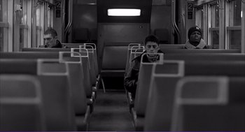 Movie still from “La haine” (1995), directed by Mathieu Kassovitz – A man sitting on a train looking out the window; Wide shot, High angle