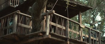 Movie still from “We Broke Up” (2021), directed by Jeff Rosenberg – A tree house with a cat sitting on it's back porch; Wide shot, Low angle