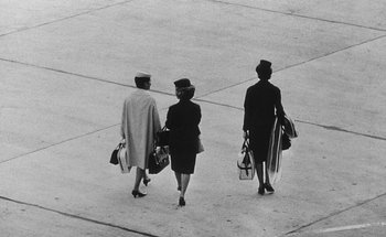 Movie still from “La Jetée” (1962), directed by Chris Marker – A group of women walking across a cement floor; Wide shot, High angle