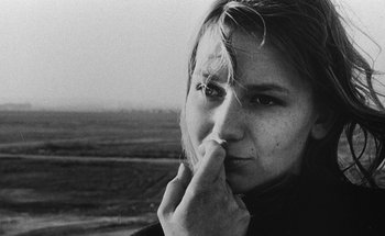 Movie still from “La Jetée” (1962), directed by Chris Marker – Black and white photograph of a woman with her hand to her face; Close Up shot, Low angle