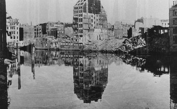 Movie still from “La Jetée” (1962), directed by Chris Marker – A black - and - white photo of a city with a reflection in the water; Extreme Wide shot, High angle