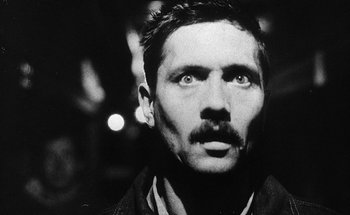 Movie still from “La Jetée” (1962), directed by Chris Marker – Black and white photograph of a man with a mustache; Close Up shot, Low angle