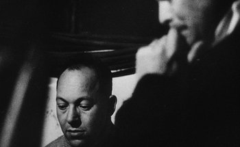 Movie still from “La Jetée” (1962), directed by Chris Marker – An old black and white photo of a man looking at another man; Close Up shot, Low angle