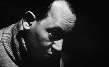 Movie still from “La Jetée” (1962), directed by Chris Marker – Black and white photograph of a man's face in the dark; Close Up shot, Low angle
