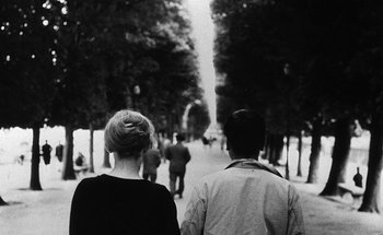 Movie still from “La Jetée” (1962), directed by Chris Marker – A man and a woman walking down a street; Close Up shot, Over the shoulder angle