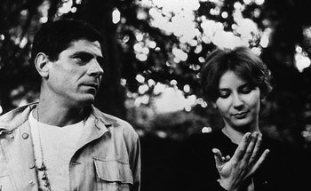 Movie still from “La Jetée” (1962), directed by Chris Marker – A man and a woman standing next to each other in front of a tree; Close Up shot, Low angle