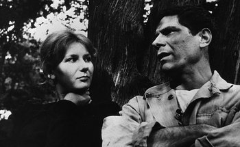 Movie still from “La Jetée” (1962), directed by Chris Marker – A man and a woman standing next to a tree; Close Up shot, Over the shoulder angle