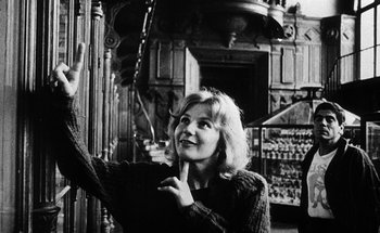 Movie still from “La Jetée” (1962), directed by Chris Marker – Black and white photograph of a woman with a hand on her chin; Medium shot, Low angle