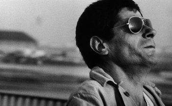 Movie still from “La Jetée” (1962), directed by Chris Marker – A black and white photo of a man wearing sunglasses; Close Up shot, Low angle
