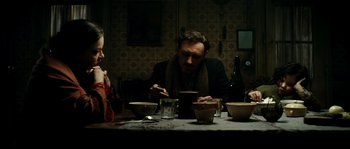 Movie still from “La Vie En Rose” (2007), directed by Olivier Dahan – A man and a woman sitting at a dinner table; Medium shot, High angle