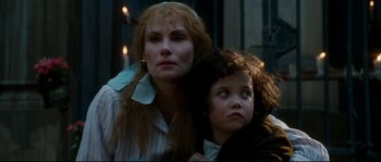 Movie still from “La Vie En Rose” (2007), directed by Olivier Dahan – A woman and a child are standing next to each other; Close Up shot, Over the shoulder angle