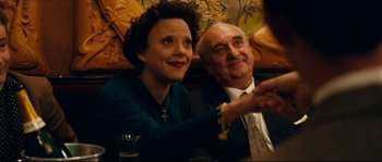 Movie still from “La Vie En Rose” (2007), directed by Olivier Dahan – An older man and a younger woman sitting next to each other; Close Up shot, High angle