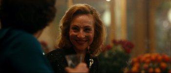 Movie still from “La Vie En Rose” (2007), directed by Olivier Dahan – A woman holding a wine glass in her hand; Close Up shot, Over the shoulder angle