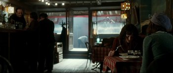 Movie still from “La Vie En Rose” (2007), directed by Olivier Dahan – Two people are sitting at a table in a restaurant; Wide shot, Over the shoulder angle