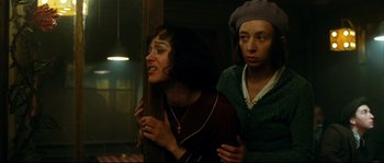 Movie still from “La Vie En Rose” (2007), directed by Olivier Dahan – Two women standing next to each other near a window; Medium shot, Low angle