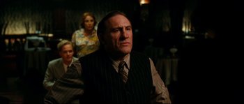 Movie still from “La Vie En Rose” (2007), directed by Olivier Dahan – An older man wearing a striped vest and a tie; Medium shot, Over the shoulder angle