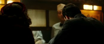 Movie still from “La Vie En Rose” (2007), directed by Olivier Dahan – A man sitting in front of another man in front of a mirror; Medium shot, Over the shoulder angle